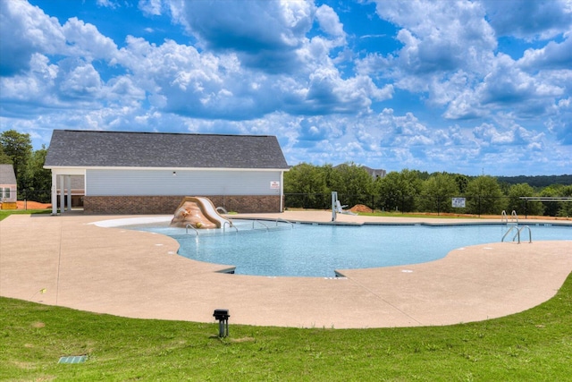 view of pool featuring a patio, a lawn, and a water slide