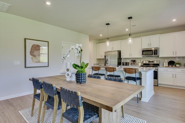 dining room with light hardwood / wood-style floors and sink