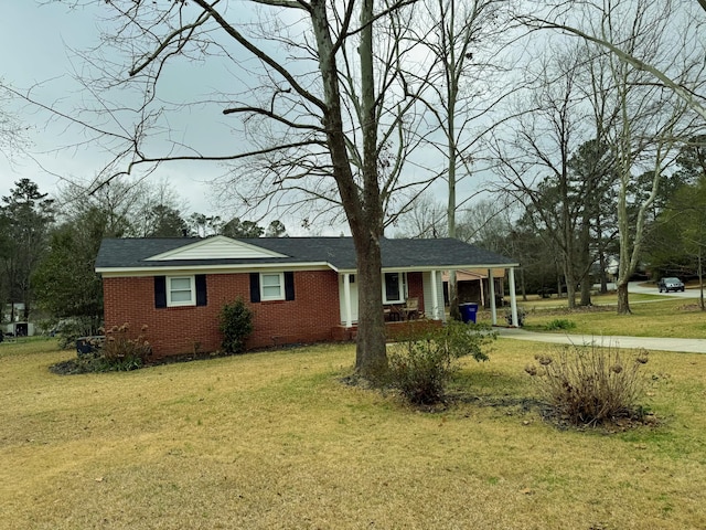 ranch-style house featuring brick siding, driveway, crawl space, a carport, and a front yard