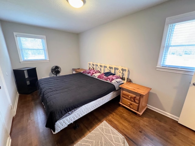 bedroom featuring wood finished floors and baseboards