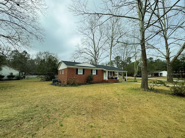 view of front of home featuring a porch, a front lawn, and brick siding