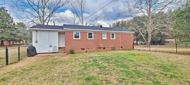 back of house with brick siding, a yard, entry steps, crawl space, and a fenced backyard