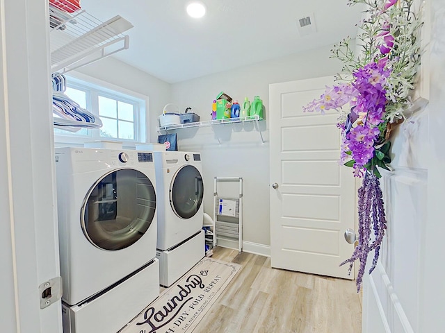 washroom with light wood-type flooring and washing machine and clothes dryer