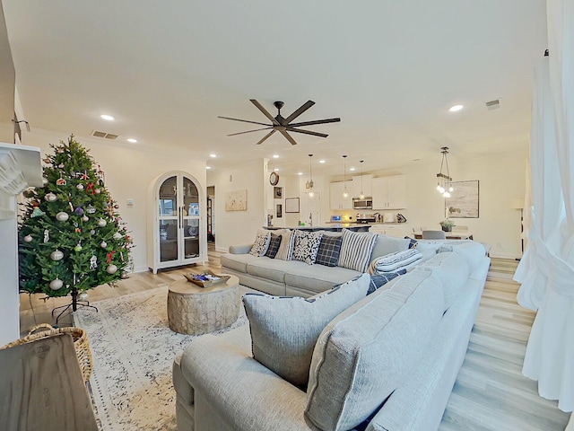 living room with light hardwood / wood-style flooring and ceiling fan