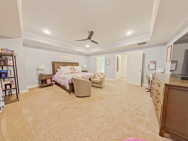 carpeted bedroom with a tray ceiling, ceiling fan, and crown molding