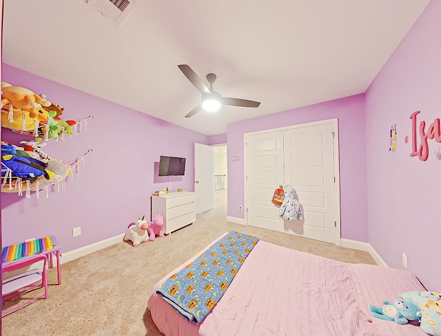 bedroom with ceiling fan, light colored carpet, and a closet