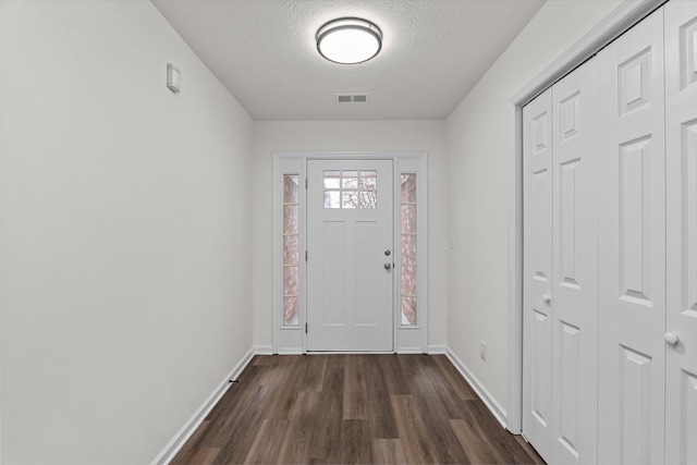 entryway with dark hardwood / wood-style flooring and a textured ceiling