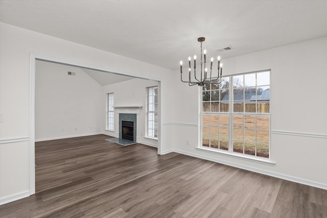 unfurnished living room featuring a high end fireplace, a wealth of natural light, and dark hardwood / wood-style flooring