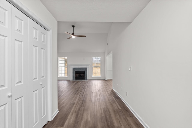 unfurnished living room with dark hardwood / wood-style flooring, vaulted ceiling, and ceiling fan