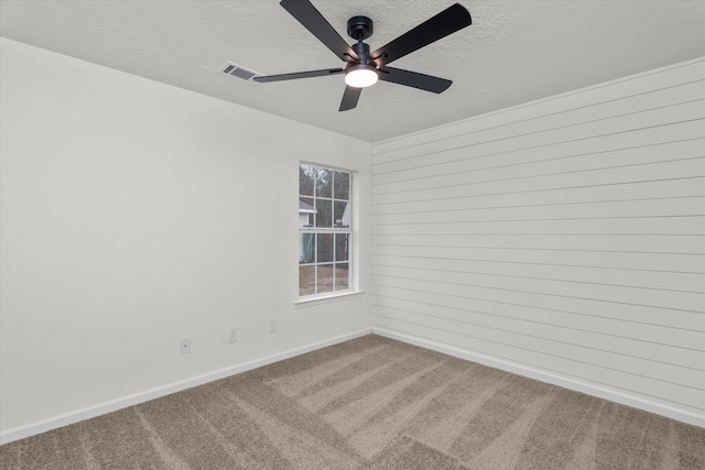 carpeted spare room featuring ceiling fan and a textured ceiling