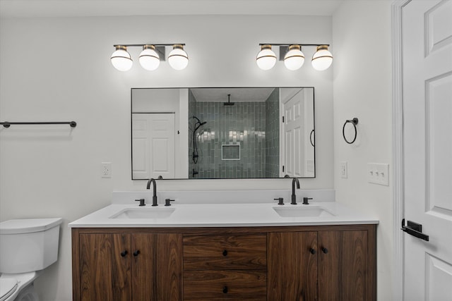 bathroom featuring vanity, toilet, and tiled shower