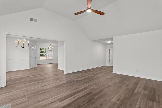 unfurnished living room featuring hardwood / wood-style flooring, lofted ceiling, and ceiling fan with notable chandelier