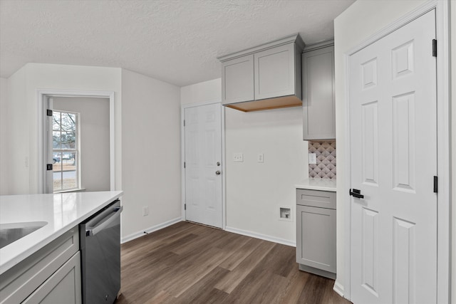 kitchen with decorative backsplash, gray cabinets, stainless steel dishwasher, and dark hardwood / wood-style floors