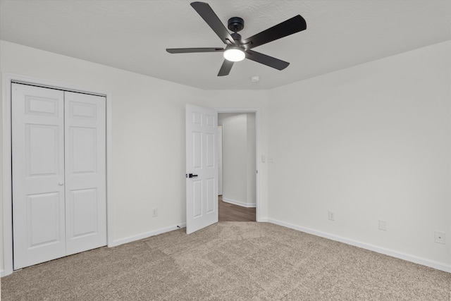 unfurnished bedroom featuring carpet floors, ceiling fan, and a closet