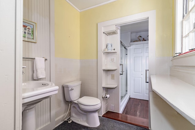 bathroom featuring sink, toilet, crown molding, and an enclosed shower