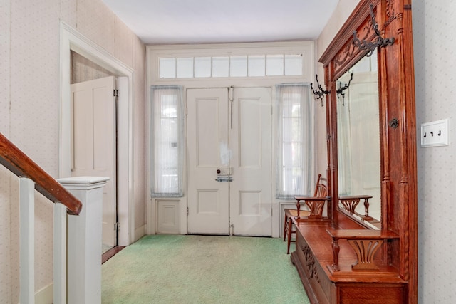 foyer entrance with light colored carpet and plenty of natural light