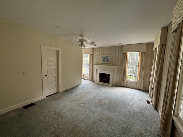 unfurnished living room featuring ceiling fan, light colored carpet, and a brick fireplace