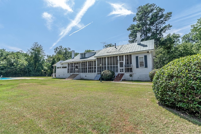 back of house with a sunroom and a yard