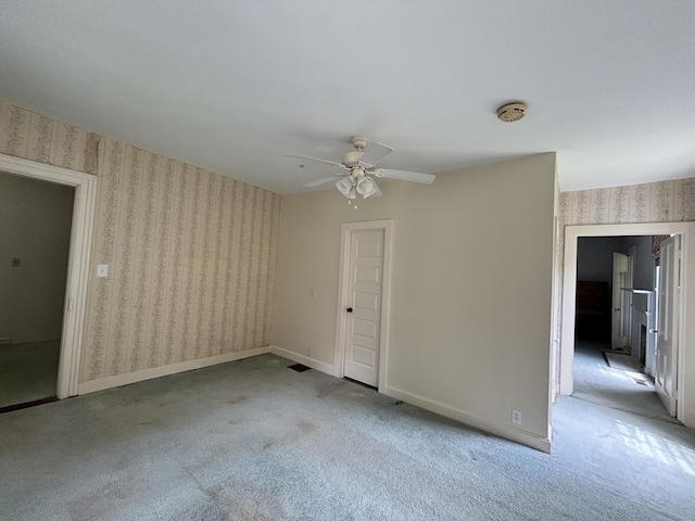 carpeted spare room with ceiling fan