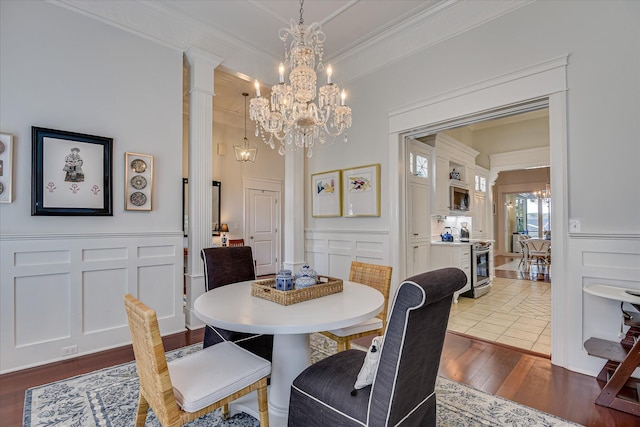 324 E Shoreline Dr, North Augusta, SC 29841 - dining area with a decorative wall, ornamental molding, a chandelier, dark wood-style flooring, and decorative columns