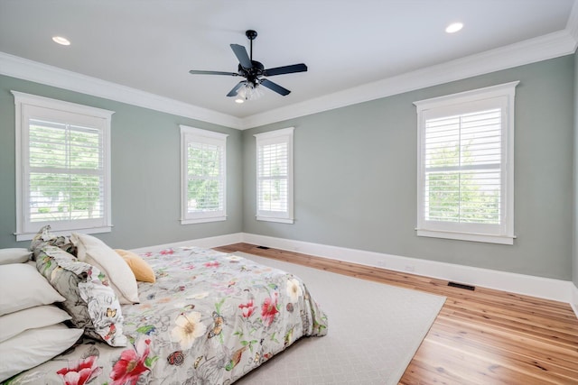 bedroom featuring baseboards, ornamental molding, and wood finished floors