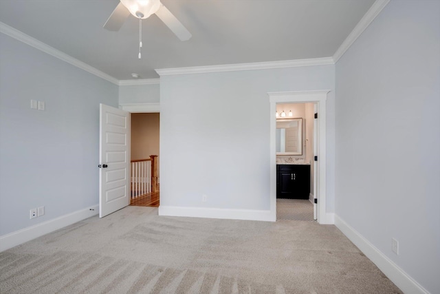 unfurnished bedroom with crown molding, baseboards, light colored carpet, and ensuite bath