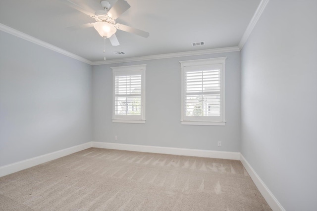 carpeted spare room with crown molding, baseboards, and visible vents