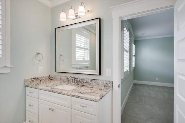 bathroom with baseboards, ornamental molding, and vanity