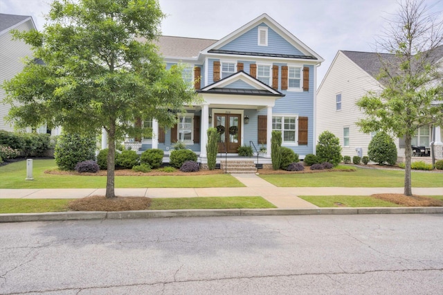 view of front facade with a porch, french doors, and a front lawn