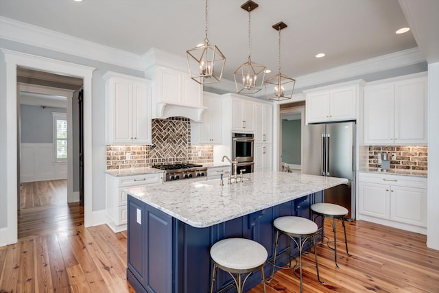 kitchen with appliances with stainless steel finishes, white cabinets, and light wood-style flooring