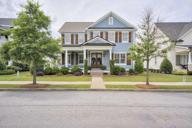 greek revival house with a front lawn, french doors, and covered porch