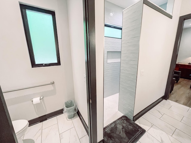 217 Cove Point Ln, Mccormick, SC 29835 - bathroom featuring marble finish floors, baseboards, toilet, and a tile shower