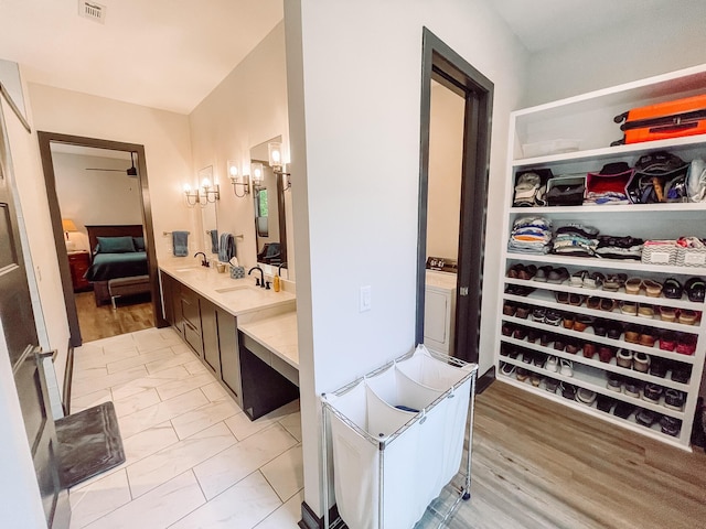 217 Cove Point Ln, Mccormick, SC 29835 - bathroom with connected bathroom, a chandelier, a walk in closet, vanity, and marble look tile flooring