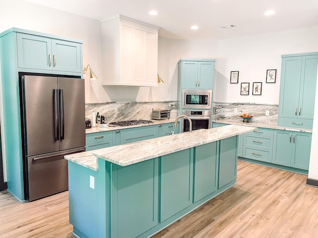 217 Cove Point Ln, Mccormick, SC 29835 - kitchen featuring stainless steel appliances, a center island with sink, light wood-style floors, light stone countertops, and recessed lighting