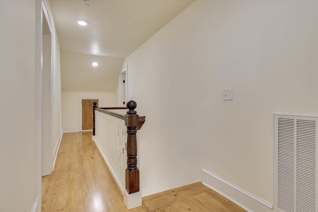 hall with vaulted ceiling and light hardwood / wood-style flooring