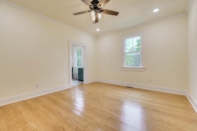 unfurnished room featuring ornamental molding, a wealth of natural light, and light hardwood / wood-style floors