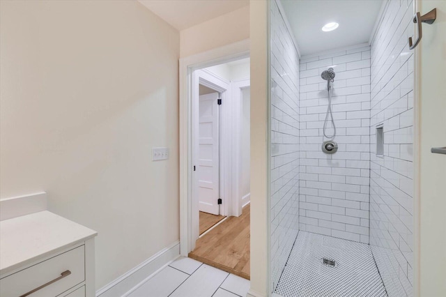 bathroom with tile patterned flooring and a tile shower