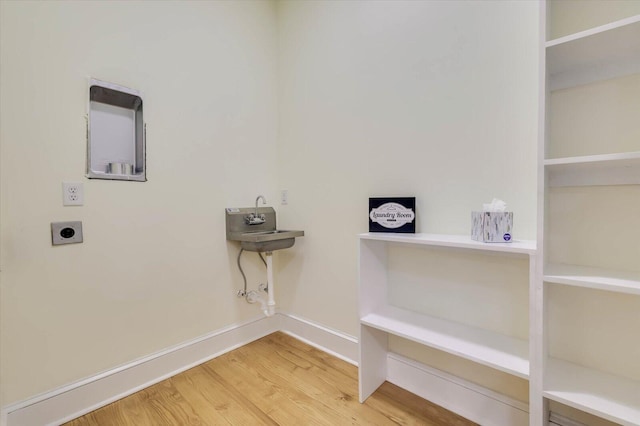 clothes washing area featuring gas dryer hookup, wood-type flooring, and hookup for an electric dryer