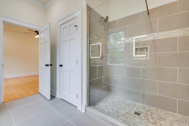 bathroom featuring walk in shower, ceiling fan, ornamental molding, and tile patterned flooring