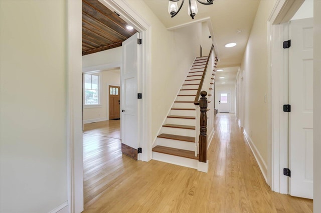 interior space with an inviting chandelier, light hardwood / wood-style floors, and a wealth of natural light