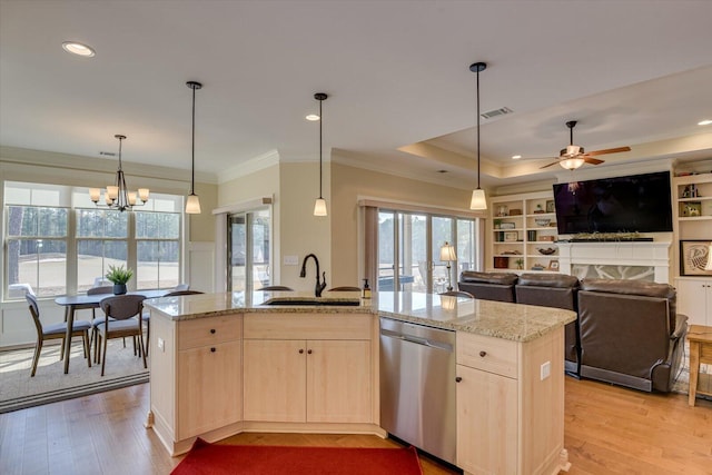 kitchen with sink, hanging light fixtures, stainless steel dishwasher, light stone counters, and a center island with sink