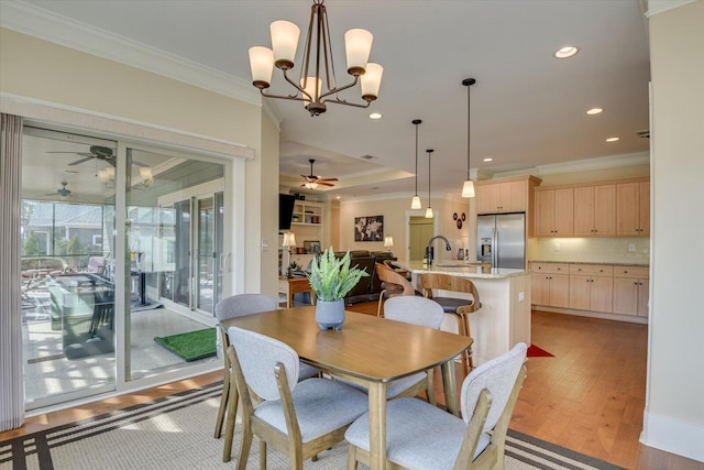 dining area with sink, crown molding, light hardwood / wood-style flooring, and ceiling fan