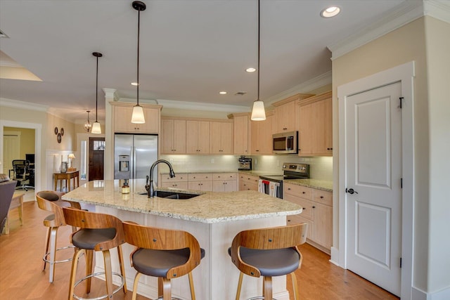 kitchen with sink, hanging light fixtures, an island with sink, and appliances with stainless steel finishes