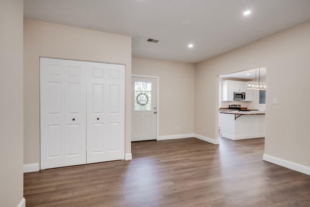 foyer featuring dark wood-type flooring and a chandelier