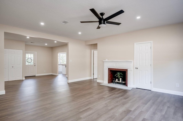 unfurnished living room featuring light hardwood / wood-style floors, a textured ceiling, and ceiling fan