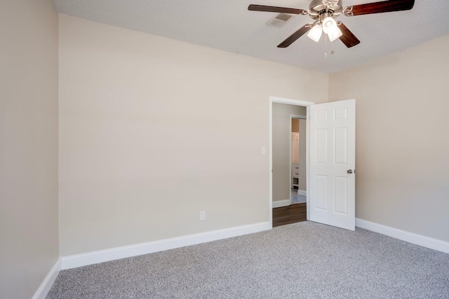 spare room with a textured ceiling, ceiling fan, and carpet floors