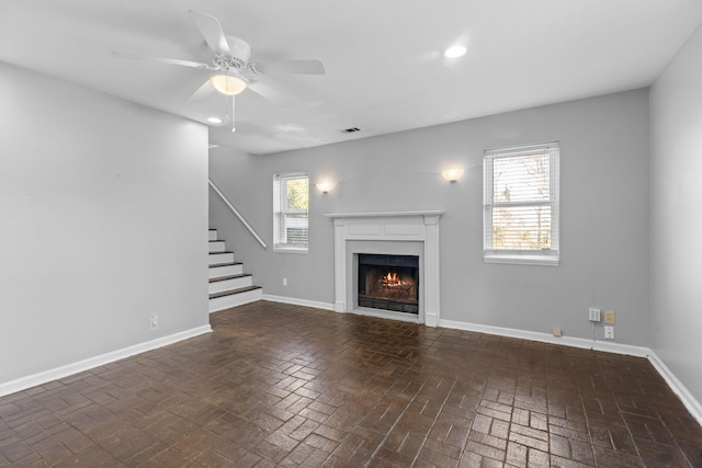 unfurnished living room with ceiling fan