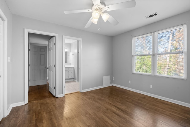 unfurnished bedroom featuring connected bathroom, ceiling fan, and dark hardwood / wood-style floors