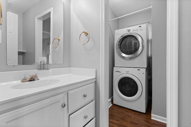 washroom featuring dark hardwood / wood-style flooring, sink, and stacked washer and clothes dryer