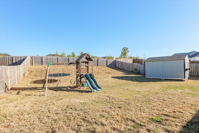 view of jungle gym featuring a trampoline, a shed, and a lawn